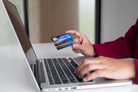 Business woman consumer holding credit card and taptop for online shopping and payment make a purchase on the Internet.の写真素材