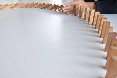 hand stop blocks wood game, gambling placing wooden block. Concept Risk of management and strategy plan, protect business to success.の写真素材