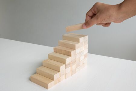 Hand holding blocks wood game, Concept Risk of management and strategy plan, growth business success process and team work.の写真素材