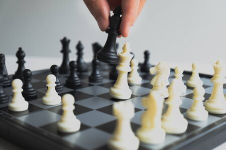 hand of businessman moving chess in competition, shows leadership, followers and business success strategies.の写真素材