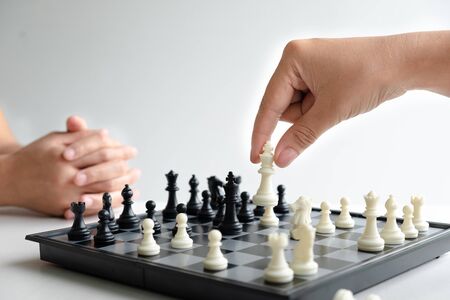 hand of businessman moving chess in competition, shows leadership, followers and business success strategies.の写真素材