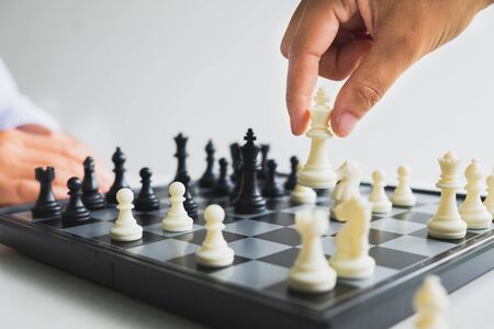 hand of businessman moving chess in competition, shows leadership, followers and business success strategies.の写真素材