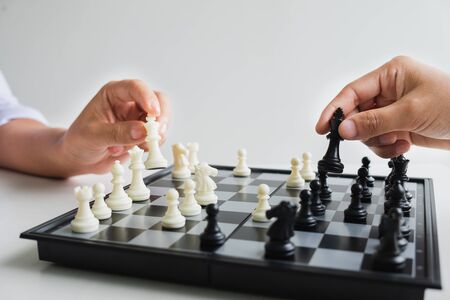hand of businessman moving chess in competition, shows leadership, followers and business success strategies.の写真素材