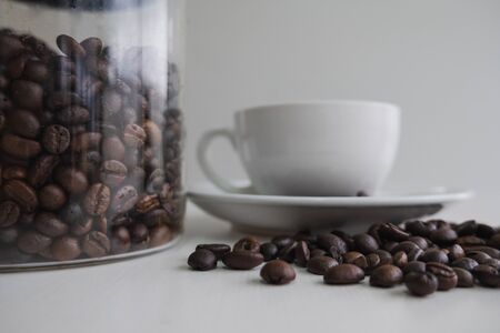 white cup and coffee bean in glass bottle.の写真素材
