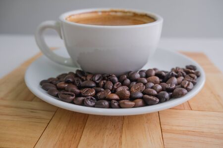 white cup and coffee bean on wood block.の写真素材