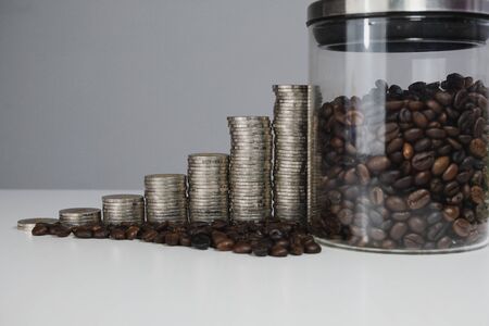 coffee bean in glass bottle with coins graph, business growth concept.の写真素材