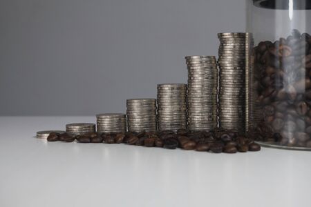 coffee bean in glass bottle with coins graph, business growth concept.