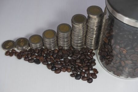 coffee bean in glass bottle with coins graph, business growth concept.の写真素材
