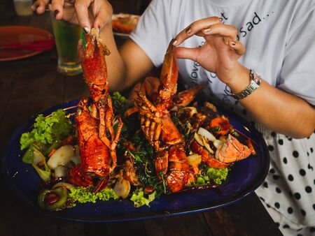 woman hand holding Fried shrimp with herb in blue dish ready for dinner.の写真素材