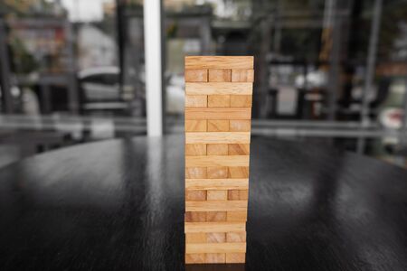 Wood block pile with architecture model with classic black tone background, Concept Risk management and strategy plan, growth business success process and team work.の写真素材