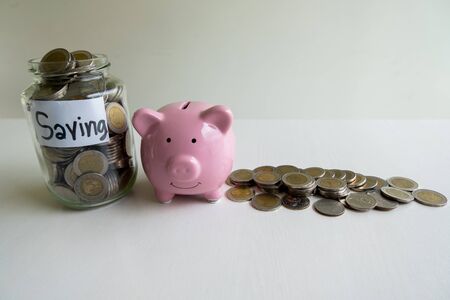 Glass and pink piggy bank with coins pile, step up growing business to success and saving for retirement  concept.の写真素材