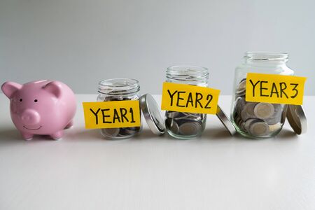 pink piggy bank with 3 years saving money plan, step up growing business to success and saving for retirement  concept.の写真素材