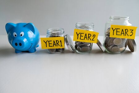 Blue piggy bank with 3 years saving money plan, step up growing business to success and saving for retirement  concept.の写真素材