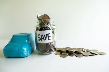 Glass and blue car piggy bank with coins pile, step up growing business to success and saving for retirement  concept.の写真素材