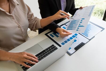 Two bussiness leader women discussing the charts, graphs and showing the results for planning management new project.の写真素材
