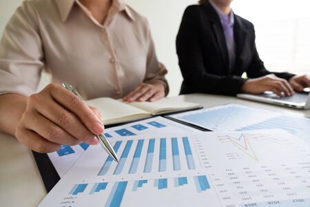 Two business leader women discussing the charts, graphs and showing the results for planning management new project.の写真素材