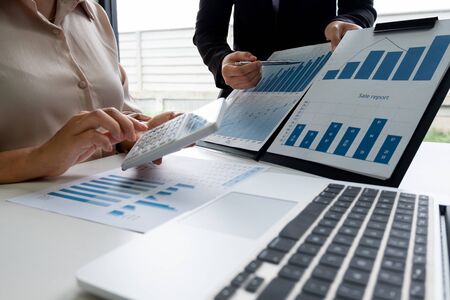 Two business leader women discussing the charts, graphs and showing the results for planning management new project.の写真素材