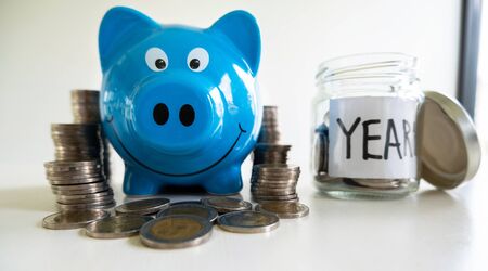 Blue piggy bank with coin pile, step up growing business to success and saving for retirement  concept.の写真素材
