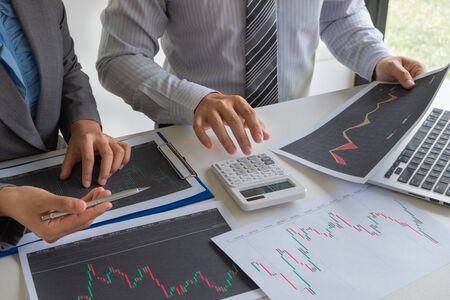 A team of business executives are planning consultations about business investments related to shares. By analyzing and calculating the stock market to find marketing profits.の写真素材