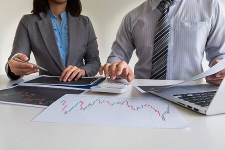 A team of business executives are planning consultations about business investments related to shares. By analyzing and calculating the stock market to find marketing profits.の写真素材