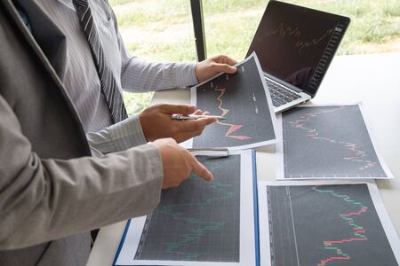 A team of business executives are planning consultations about business investments related to shares. By analyzing and calculating the stock market to find marketing profits.の写真素材