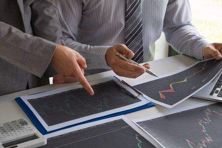 A team of business executives are planning consultations about business investments related to shares. By analyzing and calculating the stock market to find marketing profits.の写真素材