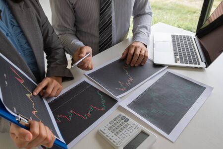 A team of business executives are planning consultations about business investments related to shares. By analyzing and calculating the stock market to find marketing profits.の写真素材