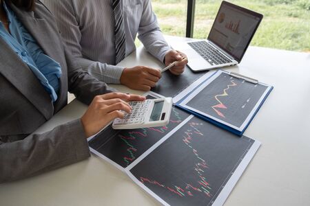 A team of business executives are planning consultations about business investments related to shares. By analyzing and calculating the stock market to find marketing profits.の写真素材