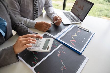 A team of business executives are planning consultations about business investments related to shares. By analyzing and calculating the stock market to find marketing profits.の写真素材
