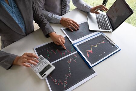 A team of business executives are planning consultations about business investments related to shares. By analyzing and calculating the stock market to find marketing profits.の写真素材