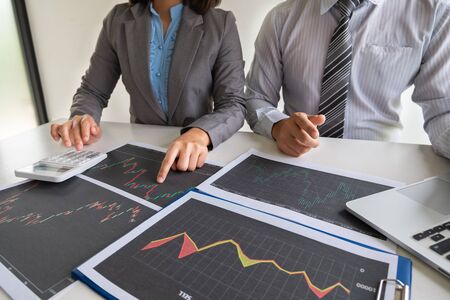 A team of business executives are planning consultations about business investments related to shares. By analyzing and calculating the stock market to find marketing profits.の写真素材