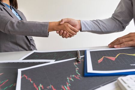shaking hands, A team of business executives are planning consultations about business investments related to shares. By analyzing and calculating the stock market to find marketing profits.の写真素材