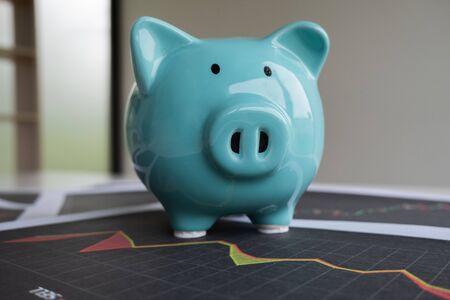 Blue piggy bank with stock graph, step up growing business to success and saving for retirement concept.の写真素材