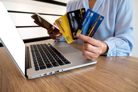 Business woman consumer holding credit card and smartphone for online shopping and payment make a...