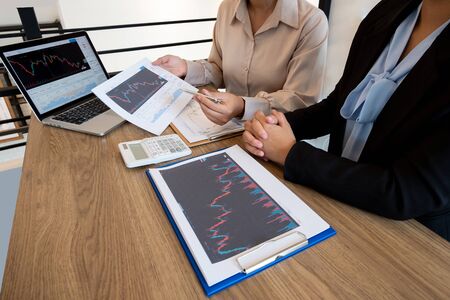 A team of business executives are planning consultations about business investments related to shares. By analyzing and calculating the stock market to find marketing profits.の写真素材