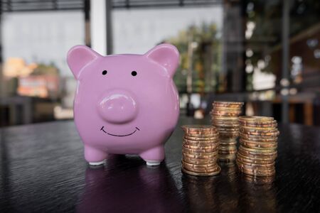 Pink piggy bank with coin pile, step up growing business to success and saving for retirement  concept.の写真素材