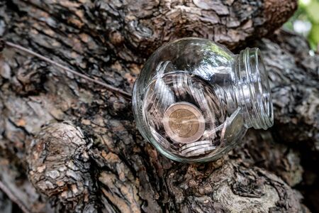 Glass jar piggy bank with coins. Plan your savings, run a growing business for success and save for retirement.の写真素材