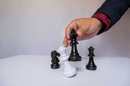 hand of businessman moving chess in competition, shows leadership, followers and business success strategies.の写真素材