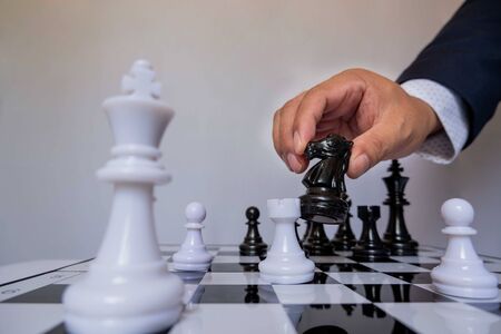 hand of businessman moving chess in competition, shows leadership, followers and business success strategies.の写真素材