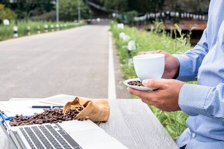 That man checks the coffee bean quality and records the results.の写真素材
