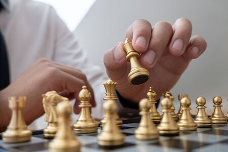 hand of businessman moving chess in competition, shows leadership, followers and business success strategies.の写真素材