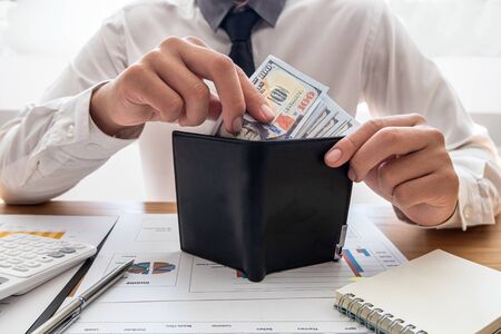 The hands of businessmen carrying dollars and wallets in order to save money, grow a successful...