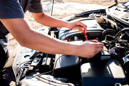 The hands of the repairman are checking the order of the engine using modern tools.の写真素材