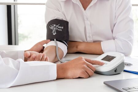 The doctor checks the blood pressure, the patients have an initial health check and talked about...