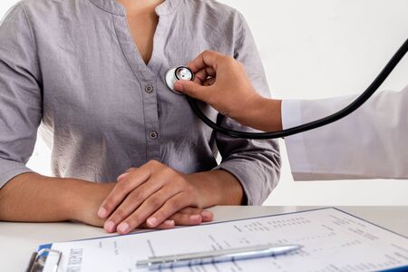 Female doctors perform a pulse examination using a stethoscope. Initial health check up at the...