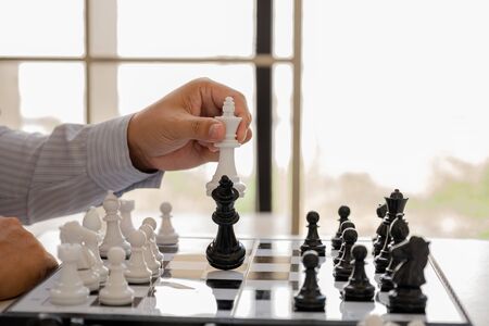 hand of businessman moving chess in competition, shows leadership, followers and business success...