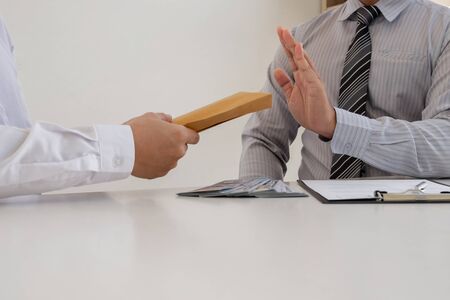 The businessman denies the money in envelope proposed by his partner to bribe the concept of bribery and corruption.の写真素材