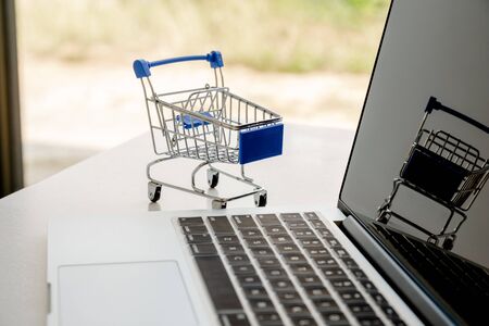 Cart placed next to a laptop keyboard Online shopping ideas.の写真素材