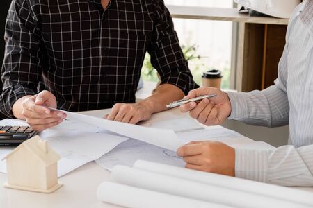 A team of confident architects working together in the office talking about construction and home...
