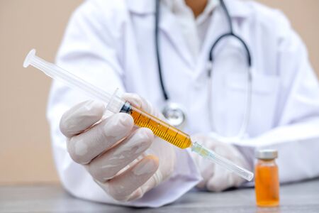 Professional doctors perform testing and analyzing samples of COVID-19 vaccines for immunization prevention and treatment from viral infections. Medical and health care concepts.の写真素材
